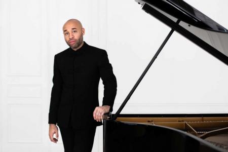 Aaron Diehl standing next to grand piano