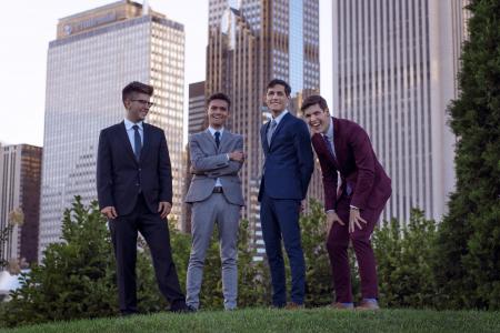 The members of NOIS saxophone quartet pose for a photo in Chicago's Grant Park with high rise buildings in the background