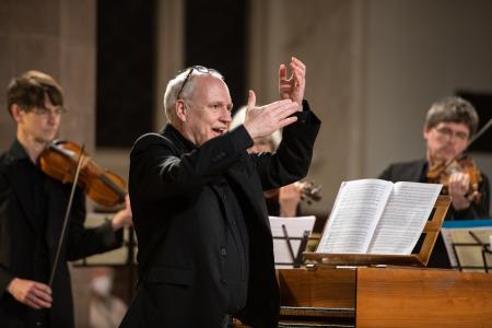 A man joyously conducts a group of musicians