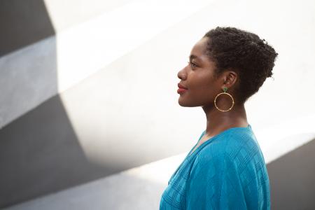 A side profile headshot of a woman in a blue shirt