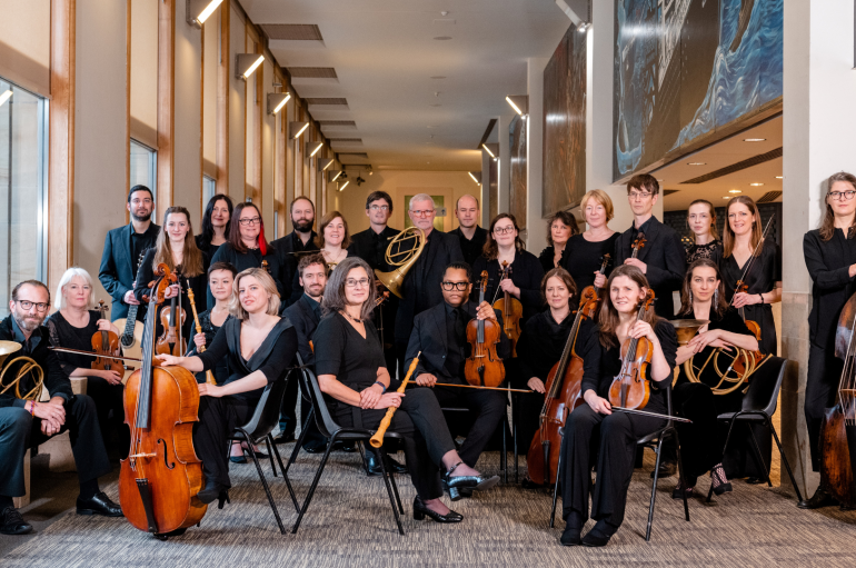 A large group of people holding musical instruments