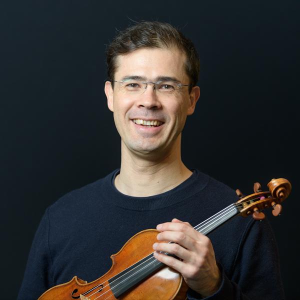 Tomo Keller stands holding his violin