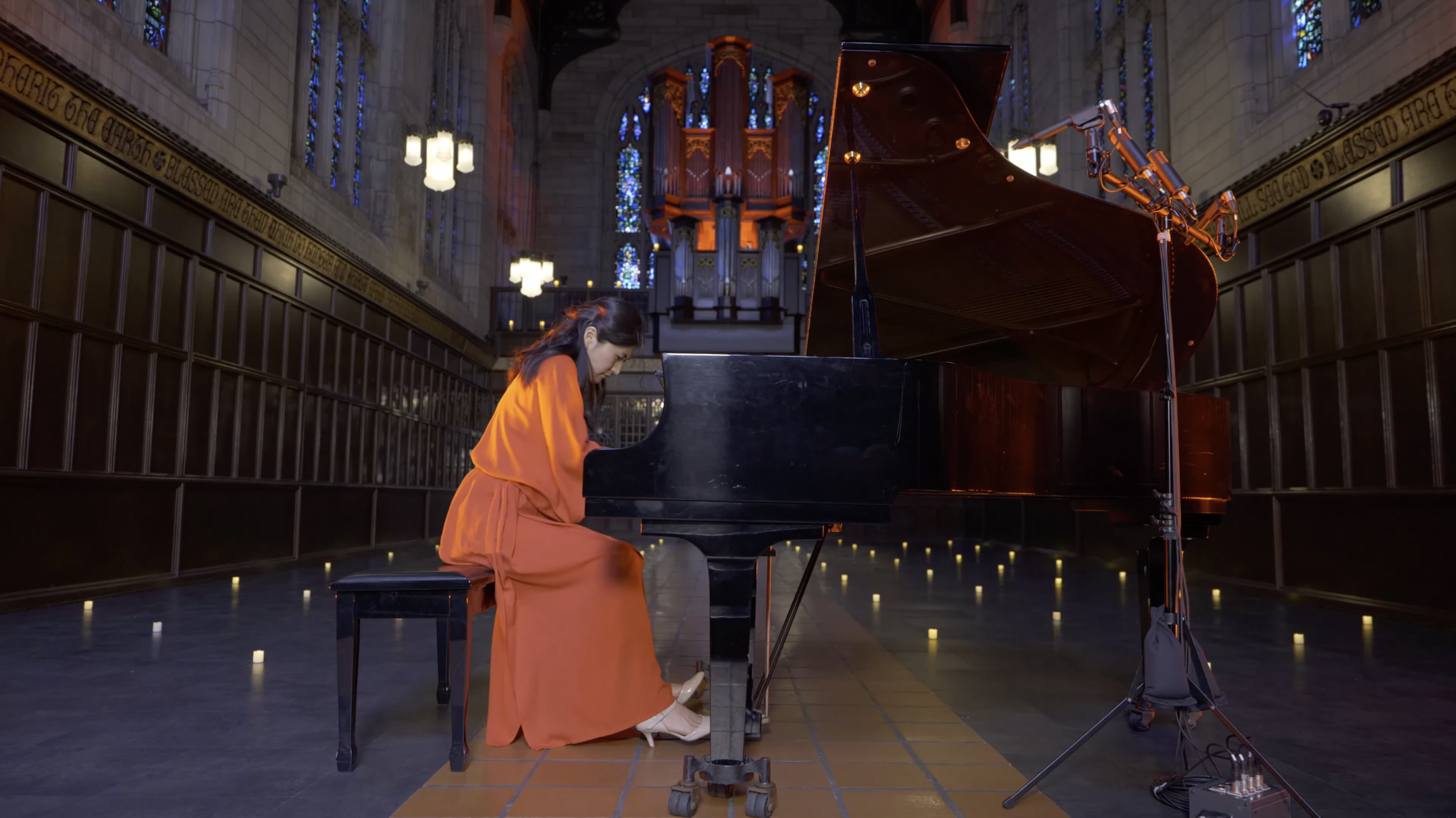 Eugenia Jeong performing on piano in Bond Chapel surrounded by fake flickering candles