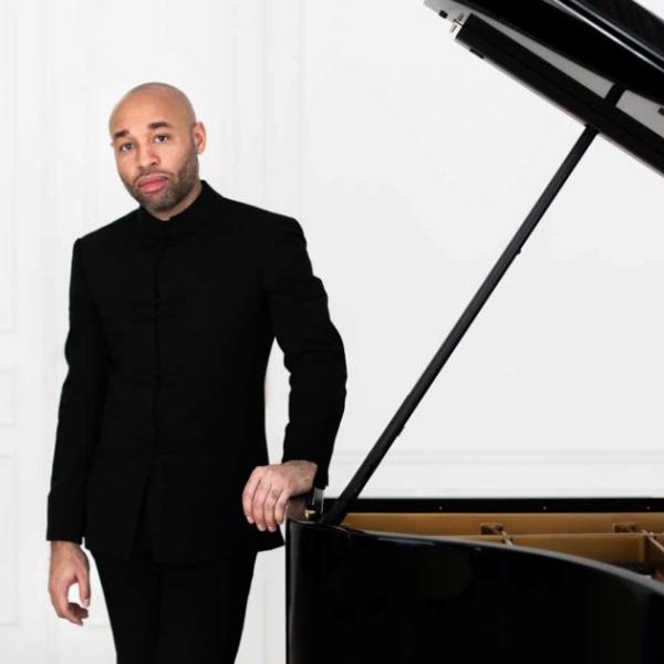 Aaron Diehl standing next to grand piano