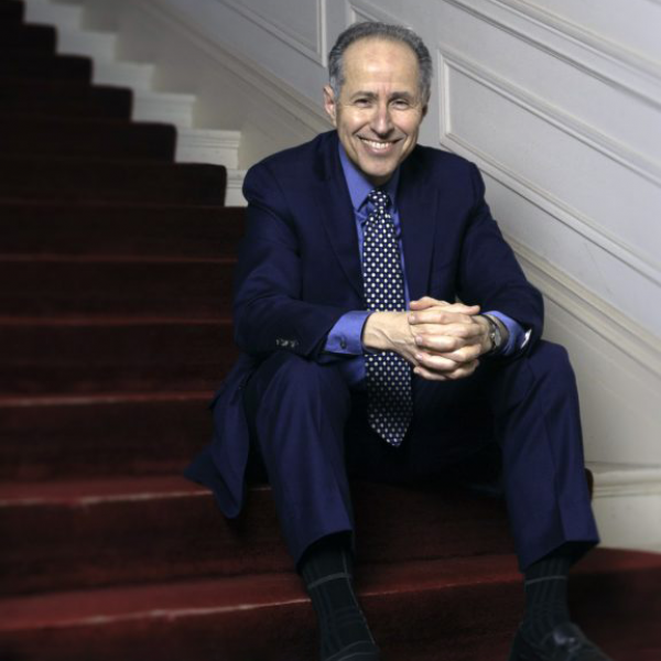 Michael Boriskin sitting on steps with a maroon rug
