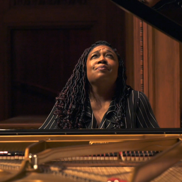 A woman sitting at a piano, looking upward