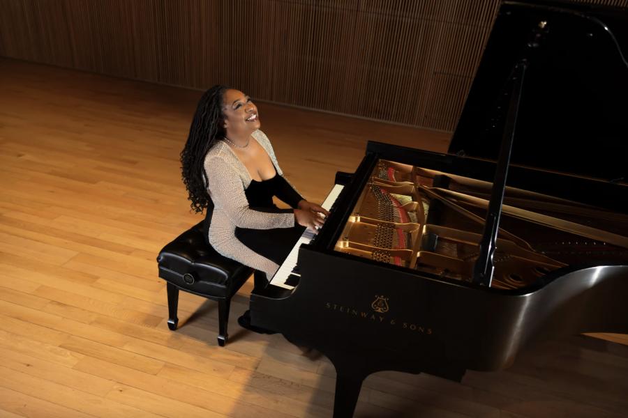 A woman sitting at a piano, smiling while looking upwards